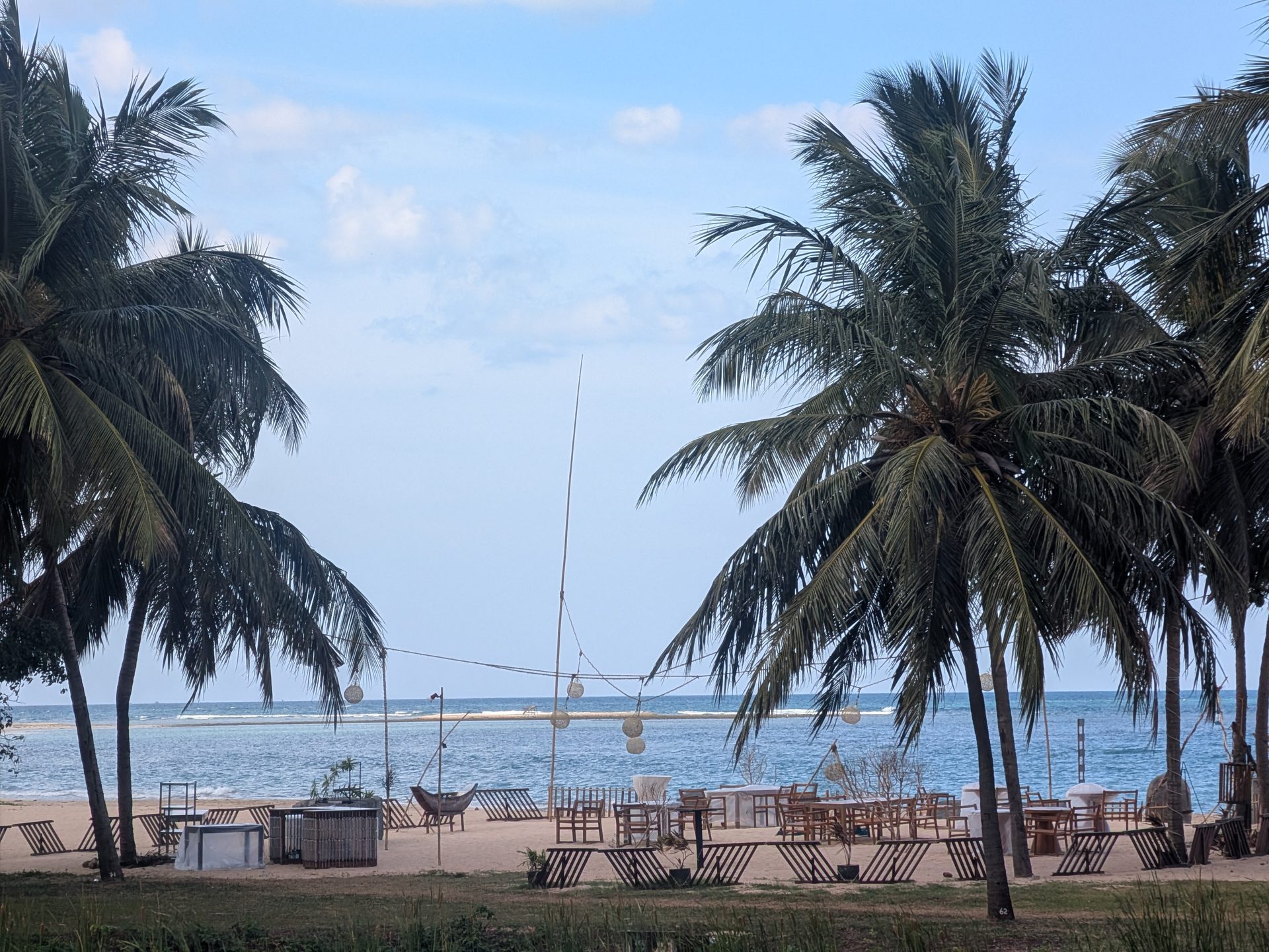 Beach dining area under palm trees at Anantaya Pasikudah