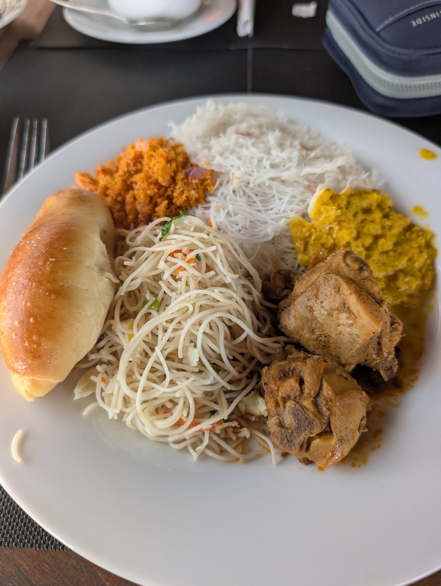 Sri Lankan breakfast plate with string hoppers, dhal, pol sambol and chicken curry