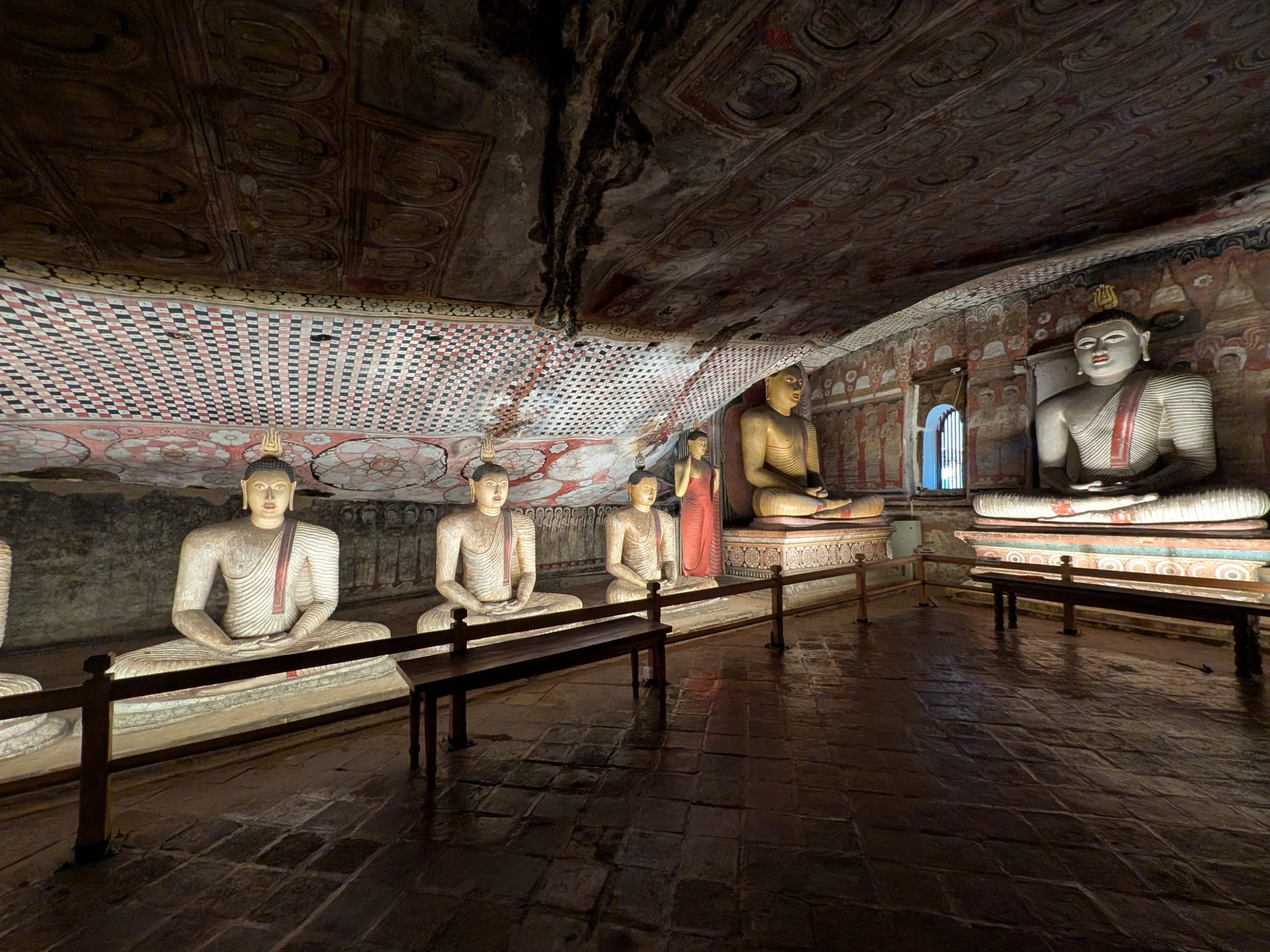 Row of seated Buddha statues inside a Dambulla cave