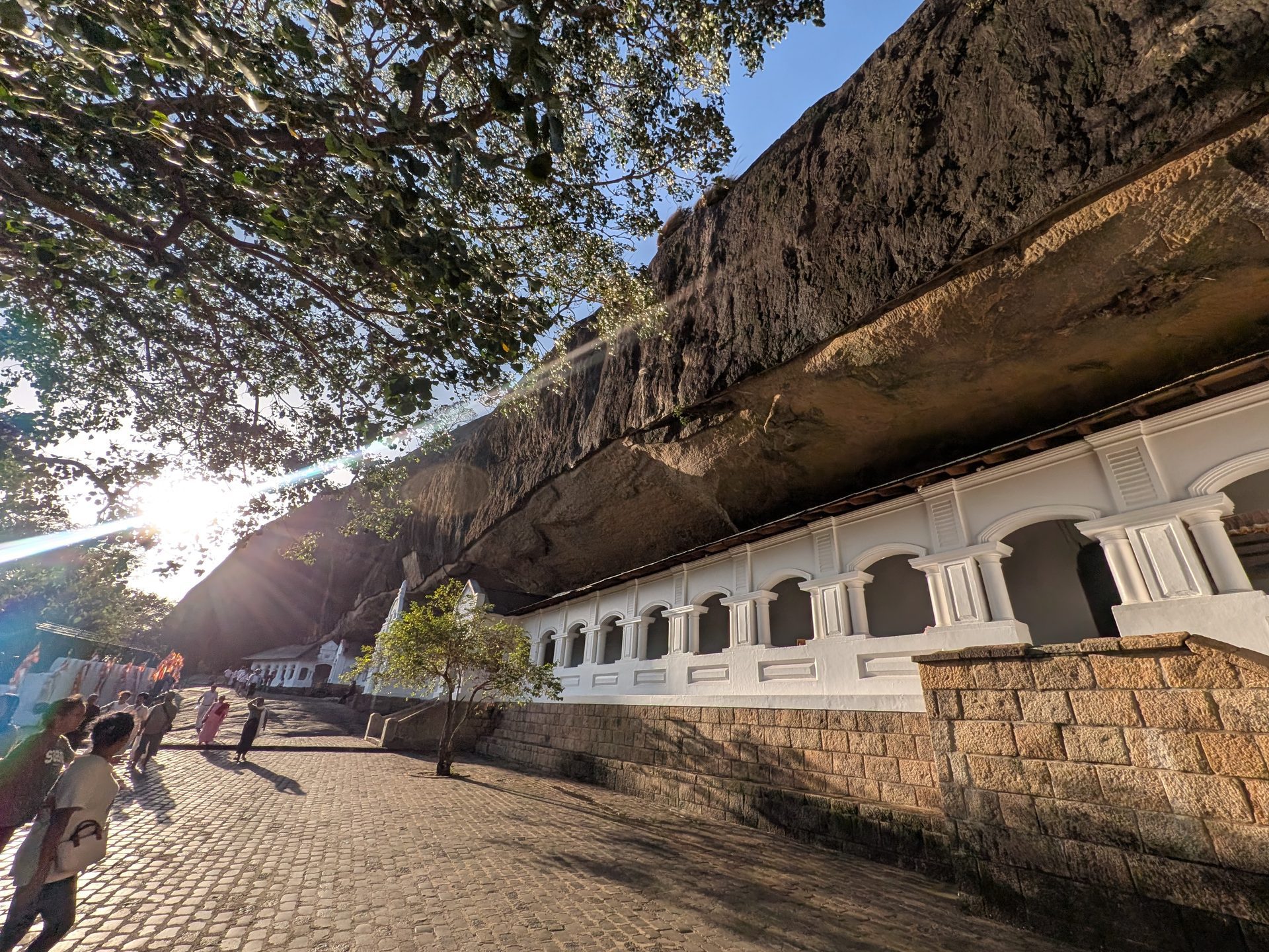 White colonnade built under the rock at Dambulla Cave Temple