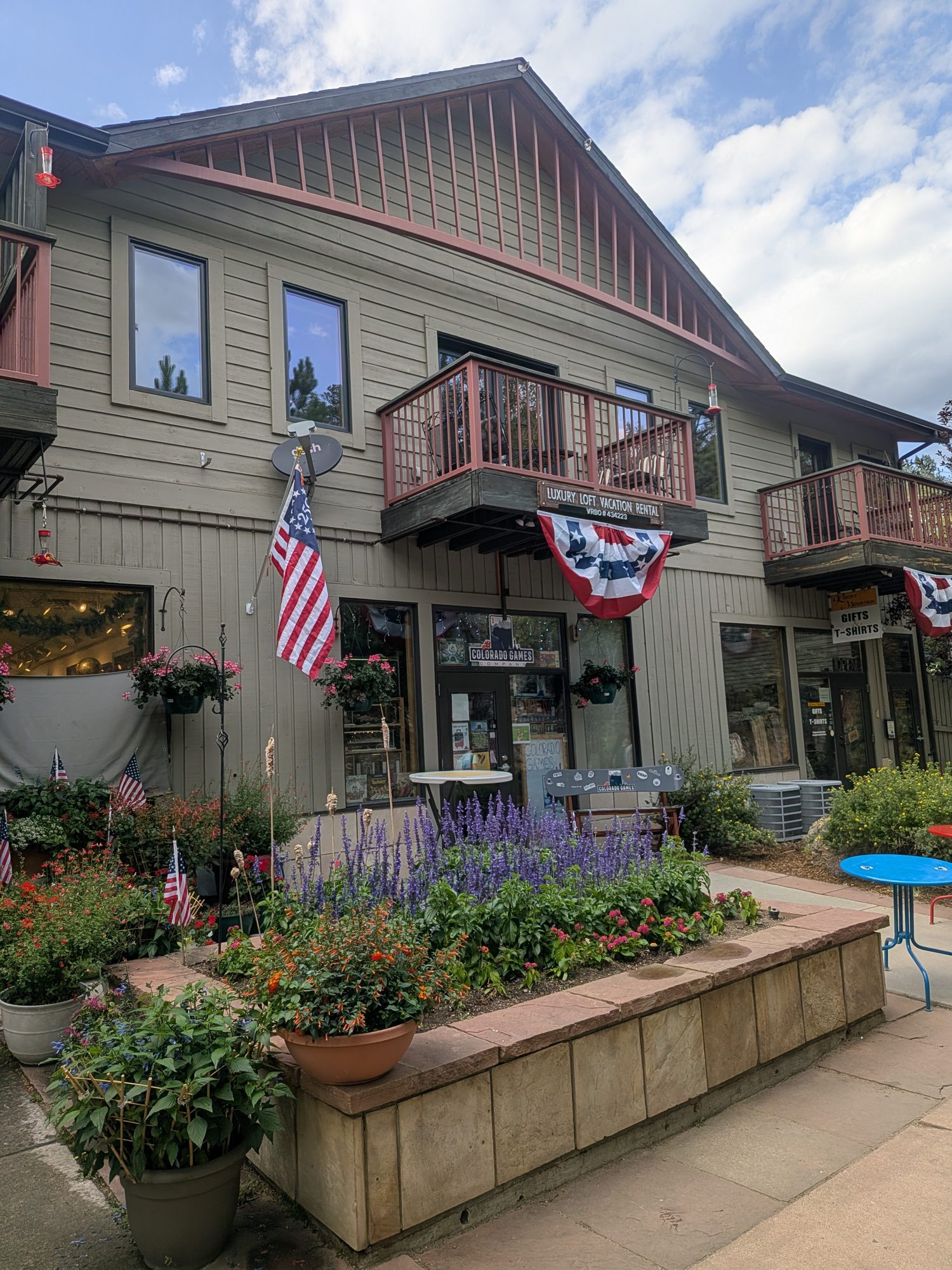 Shops with flower boxes and flags in downtown Estes Park near the Riverwalk