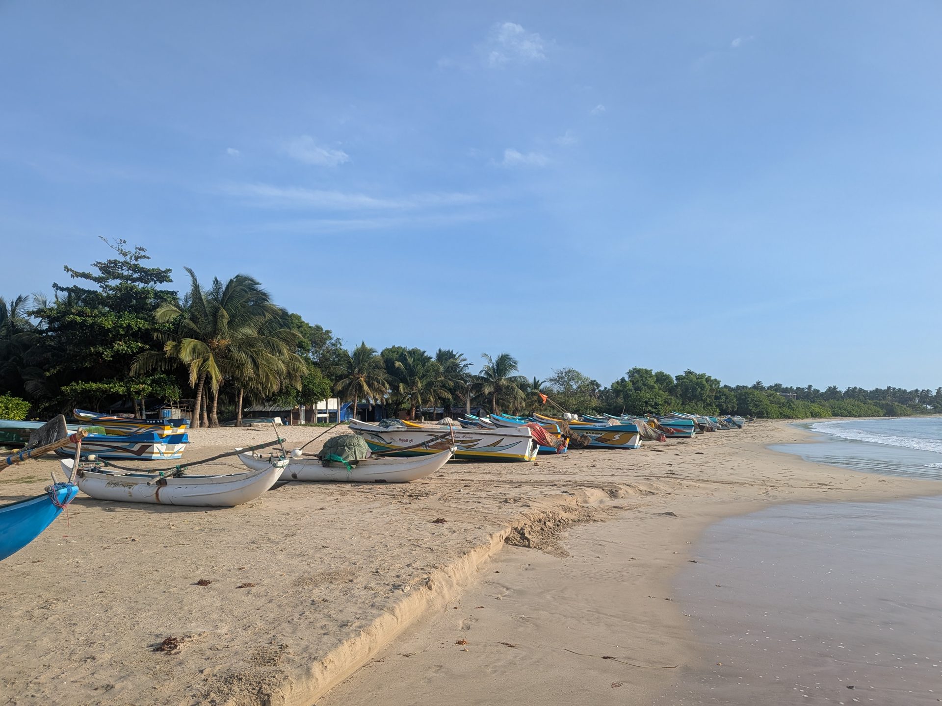 Fishing boats lined up on Pasikudah beach in the morning