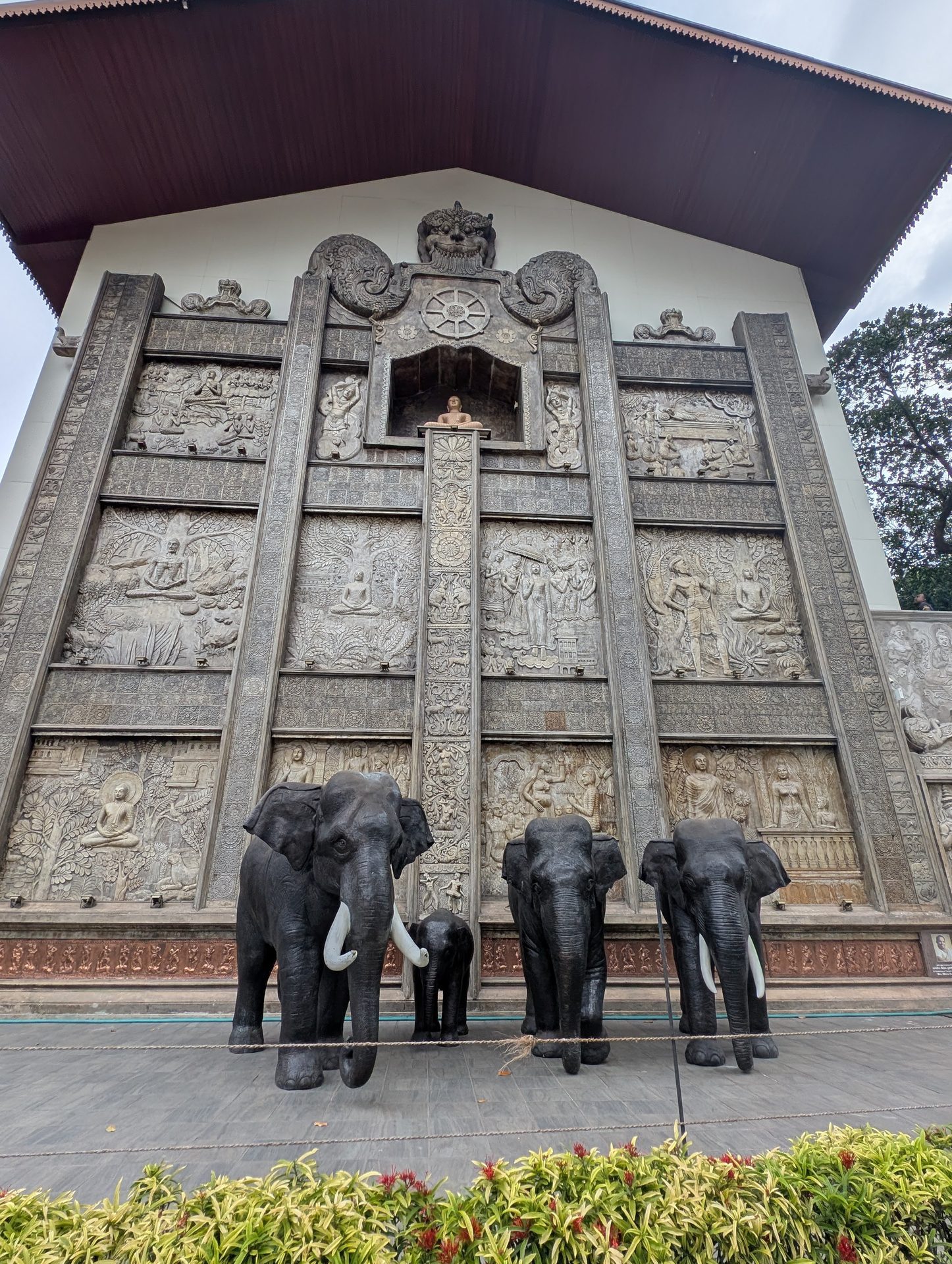 Carved wall with elephant statues outside Gangaramaya Temple