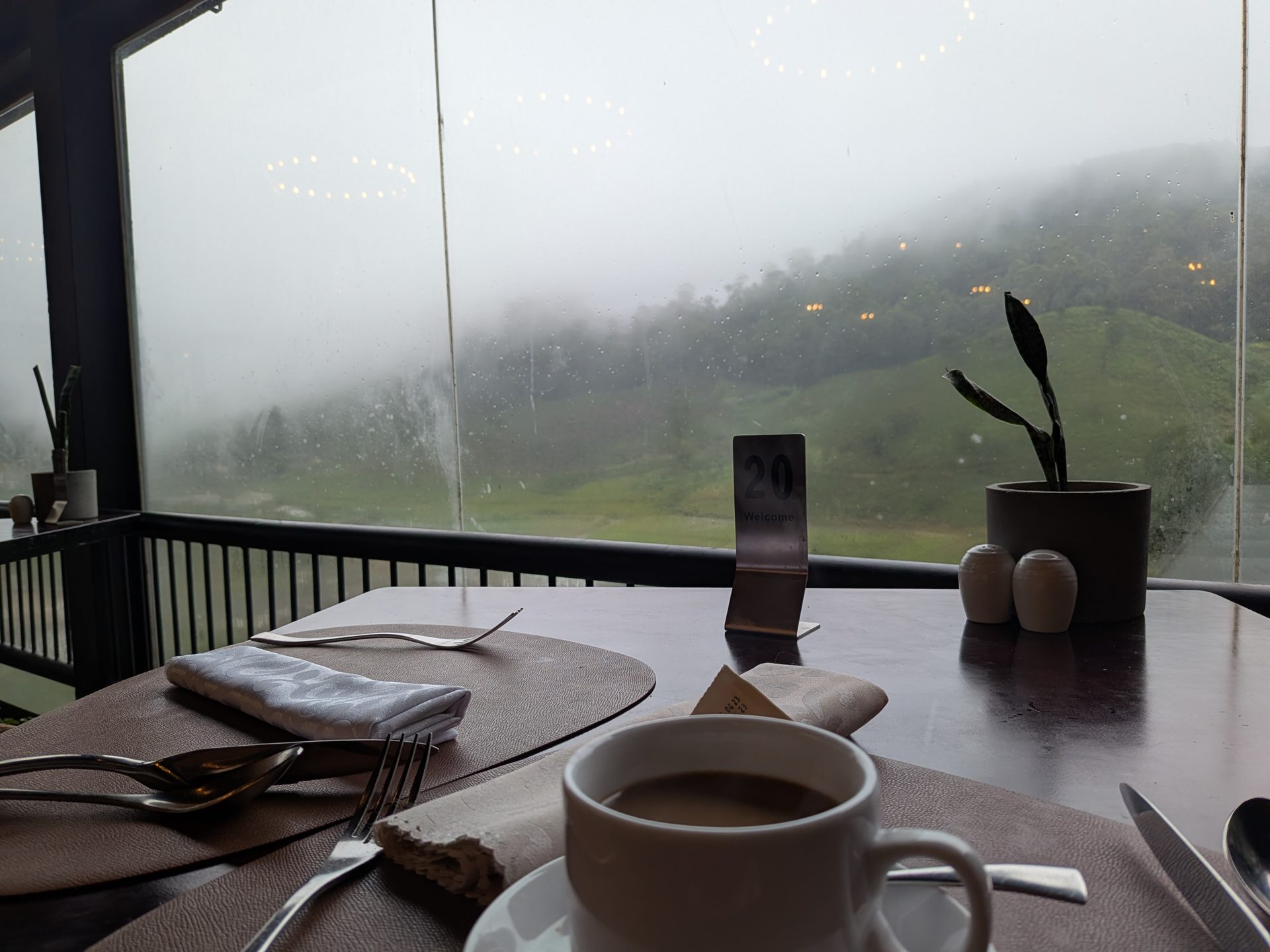 Breakfast table with a misty valley view at The Golden Ridge Hotel