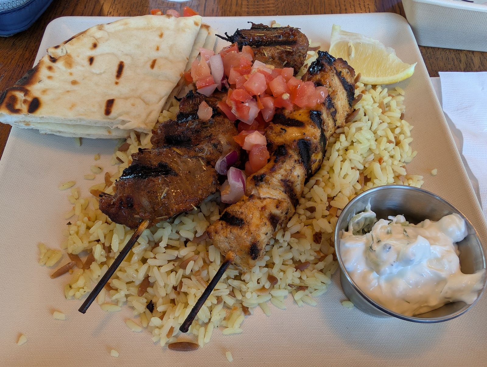 Chicken souvlaki kabob plate with rice pilaf, pita and tzatziki