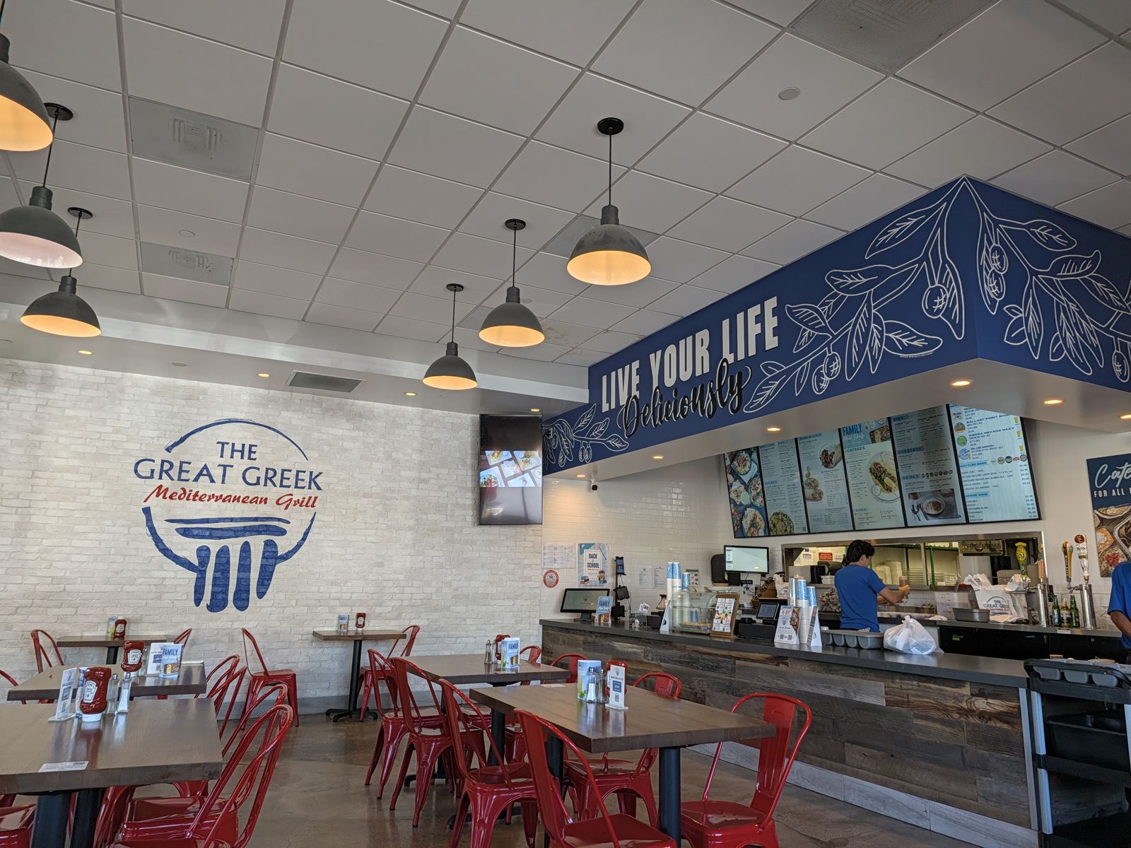 Dining room with red chairs and the order counter at The Great Greek Irvine