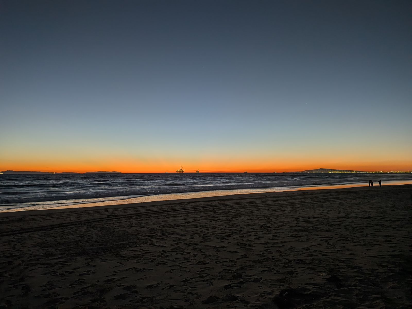 Orange glow on the horizon after sunset at Huntington Beach