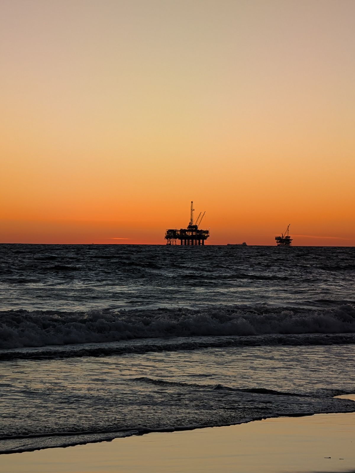 Oil platforms on the horizon at dusk off Huntington Beach