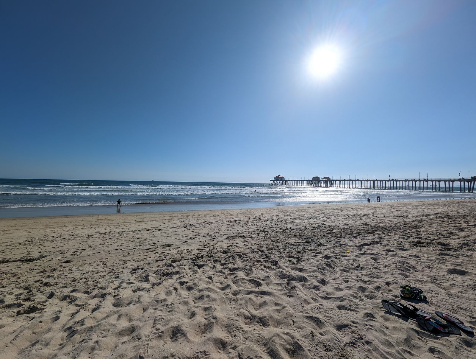 Wide stretch of sand at Huntington City Beach with the pier in the distance