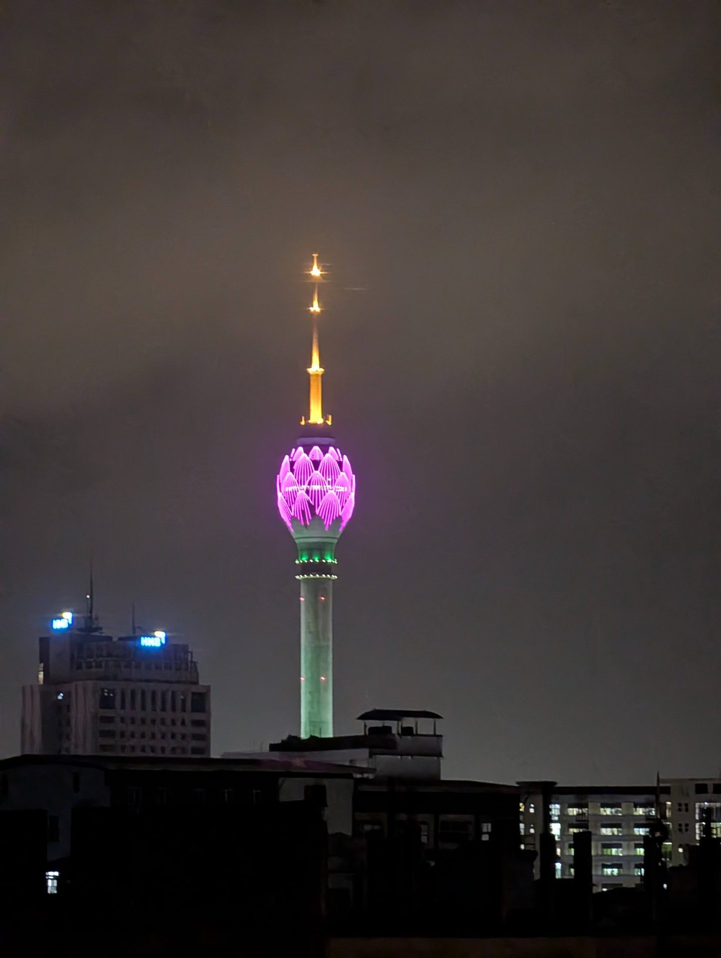 Lotus Tower lit pink at night from Colombo 7