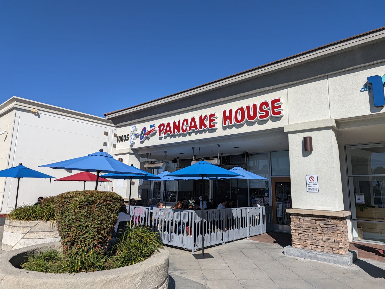 Outdoor patio with blue umbrellas at The Original Pancake House Huntington Beach
