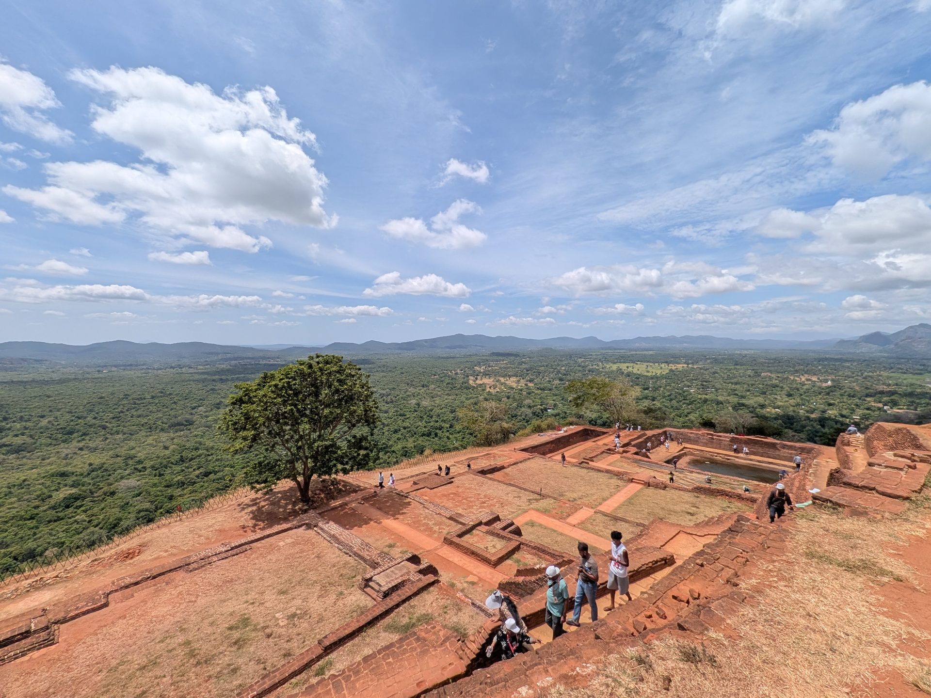 Visitors walking among palace foundations on Sigiriya
