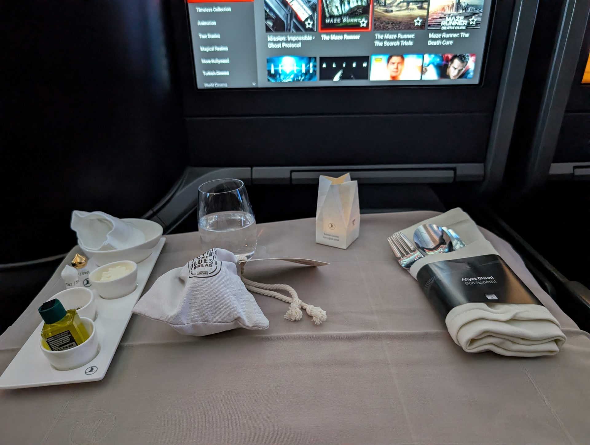 Table setting with olive oil, bread bag and menu in Turkish Airlines business class