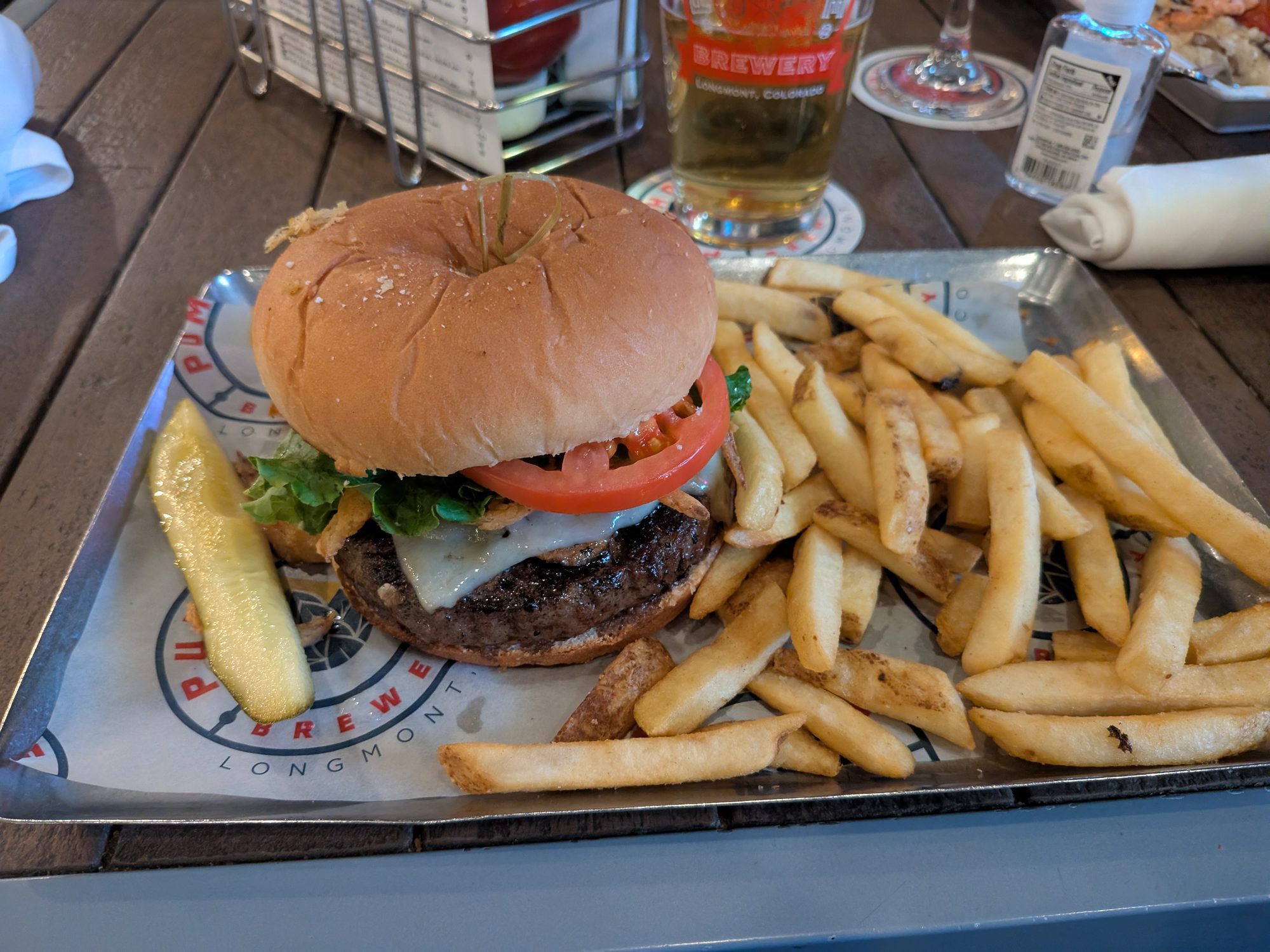 Whiskey burger with fries and a pickle spear at Pumphouse Brewery in Longmont